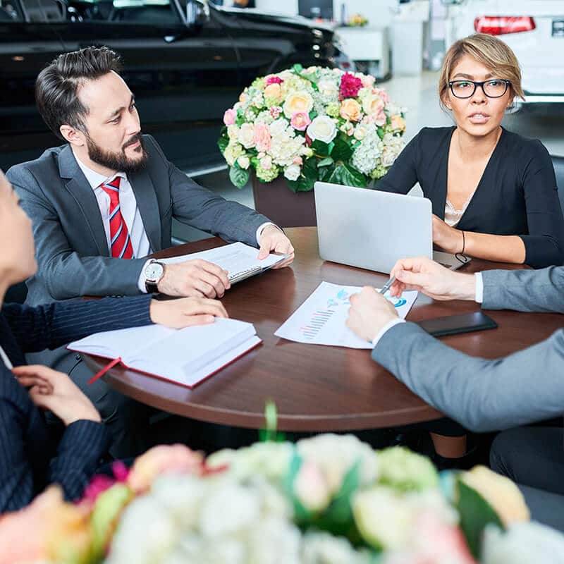 business people meeting at table in dealership